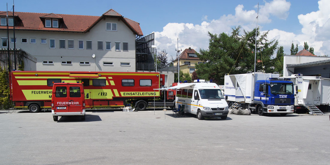 Fahrzeuge verschiedener Hilfsorganisationen stehen auf einem Hof und symbolisieren die Zusammenarbeit verschiedener Organisationen Fahrzeuge verschiedener Hilfsorganisationen stehen auf einem Hof und symbolisieren die Zusammenarbeit verschiedener Organisationen