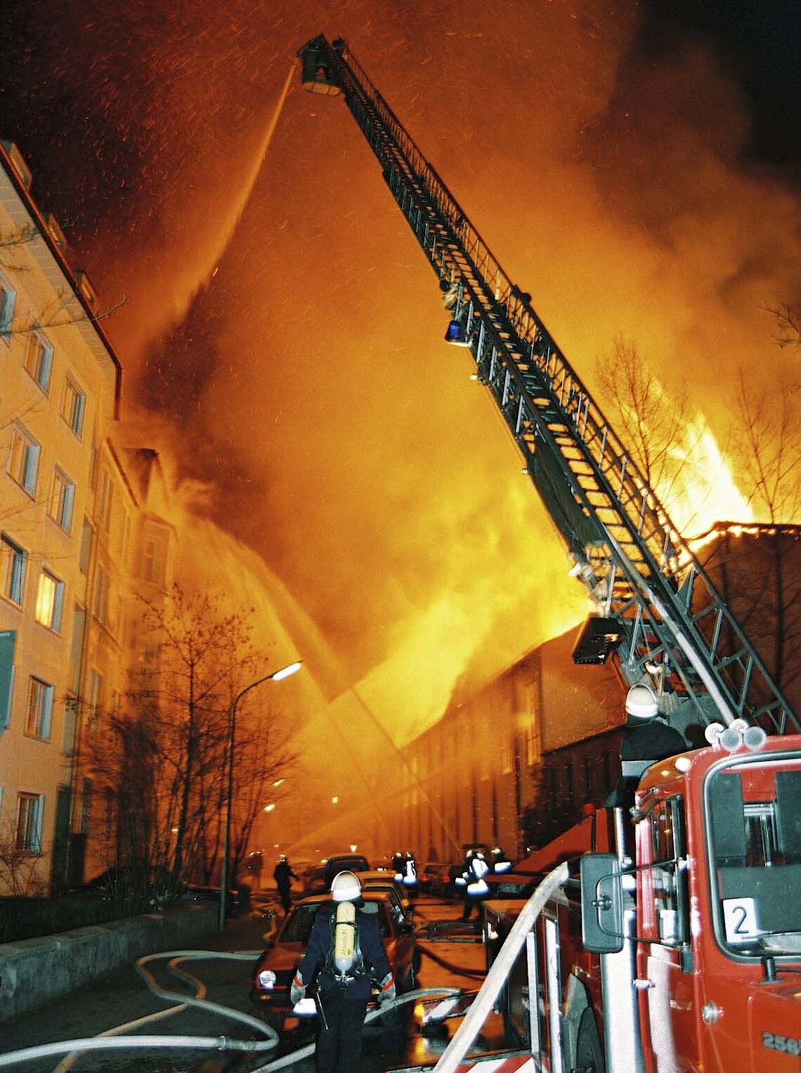 Feuerwehr bei nächtlichen Löscharbeiten an der Herz-Jesu-Kirche, Drehleiter im Vordergrund